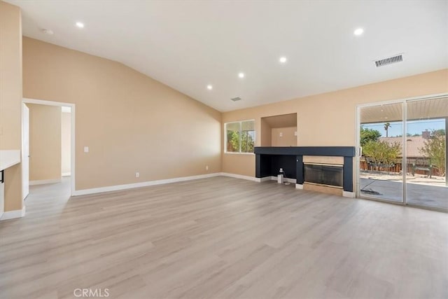 66101 14th St, Desert Hot Springs, CA 92240 - unfurnished living room featuring lofted ceiling, light wood-type flooring, a glass covered fireplace, and recessed lighting