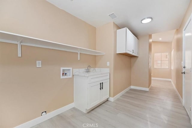 66101 14th St, Desert Hot Springs, CA 92240 - laundry area with hookup for a washing machine, light wood-type flooring, and cabinet space