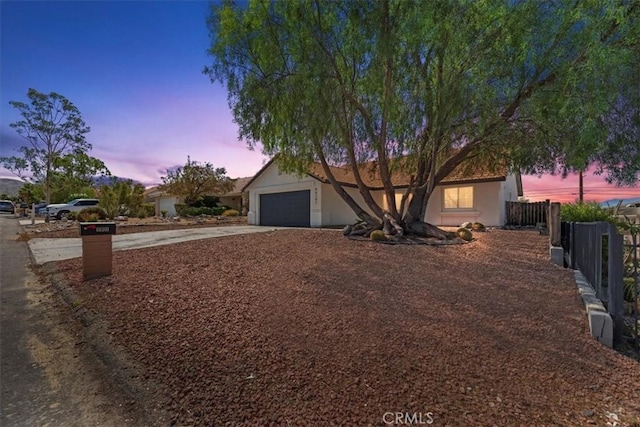 66101 14th St, Desert Hot Springs, CA 92240 - view of property hidden behind natural elements with driveway, an attached garage, and stucco siding