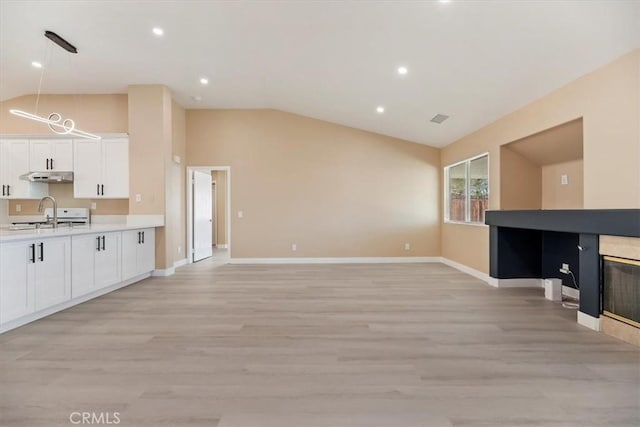 66101 14th St, Desert Hot Springs, CA 92240 - unfurnished living room featuring vaulted ceiling, light wood-style floors, and recessed lighting
