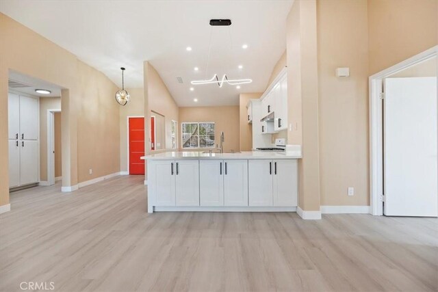 66101 14th St, Desert Hot Springs, CA 92240 - kitchen featuring light wood-style flooring, white cabinets, a chandelier, light countertops, and vaulted ceiling