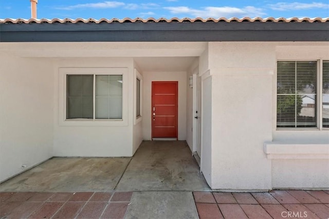 66101 14th St, Desert Hot Springs, CA 92240 - view of exterior entry featuring stucco siding and a tile roof