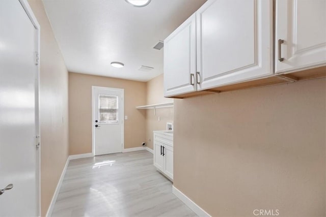 66101 14th St, Desert Hot Springs, CA 92240 - laundry room with washer hookup, cabinet space, and light wood finished floors