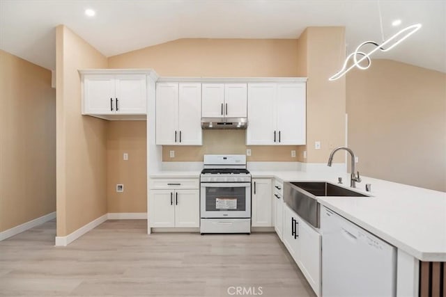66101 14th St, Desert Hot Springs, CA 92240 - kitchen with white appliances, under cabinet range hood, lofted ceiling, a peninsula, and light wood-style flooring