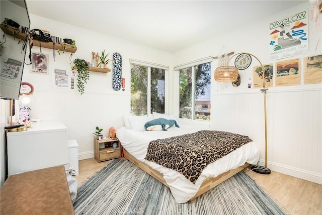 16521 Grunion Ln Unit 207, Huntington Beach, CA 92649 - bedroom with light wood-type flooring and a wainscoted wall