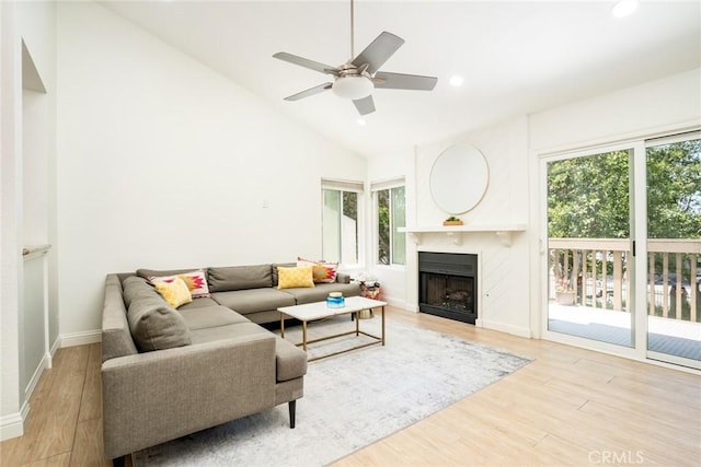 16521 Grunion Ln Unit 207, Huntington Beach, CA 92649 - living area featuring vaulted ceiling, light wood finished floors, a fireplace, ceiling fan, and recessed lighting