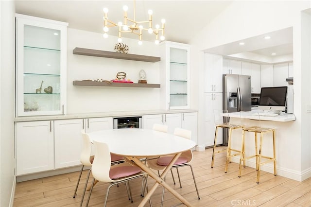16521 Grunion Ln Unit 207, Huntington Beach, CA 92649 - dining room featuring light wood-style flooring, wine cooler, a bar, a chandelier, and recessed lighting
