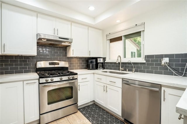 16521 Grunion Ln Unit 207, Huntington Beach, CA 92649 - kitchen with appliances with stainless steel finishes, under cabinet range hood, white cabinetry, decorative backsplash, and recessed lighting
