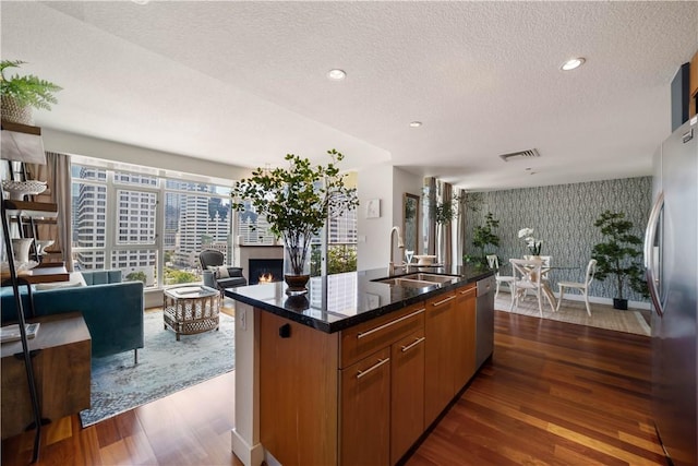 1199 Pacific Unit 1303, San Diego, CA 92101 - kitchen featuring wallpapered walls, appliances with stainless steel finishes, a warm lit fireplace, dark wood-type flooring, and open floor plan