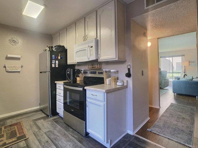 12553 Mapleview St Unit 28, Lakeside, CA 92040 - kitchen with appliances with stainless steel finishes, light countertops, wood finished floors, and white cabinetry
