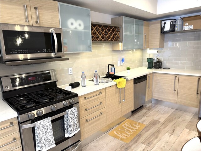 1234 Wilshire Blvd Unit 330, Los Angeles, CA 90017 - kitchen with stainless steel appliances, light wood-type flooring, and backsplash