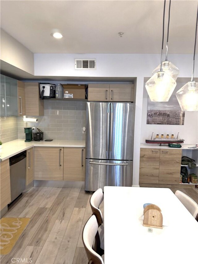 1234 Wilshire Blvd Unit 330, Los Angeles, CA 90017 - kitchen featuring stainless steel appliances, light wood finished floors, modern cabinets, tasteful backsplash, and light countertops