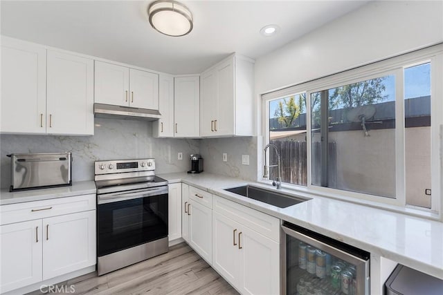 7147 Fulton Way, Stanton, CA 90680 - kitchen featuring stainless steel range with electric stovetop, wine cooler, under cabinet range hood, light countertops, and recessed lighting
