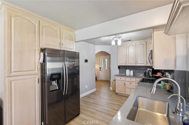 1776 San Bernardino Ave, Pomona, CA 91767 - kitchen featuring appliances with stainless steel finishes, arched walkways, light brown cabinetry, and light wood-type flooring