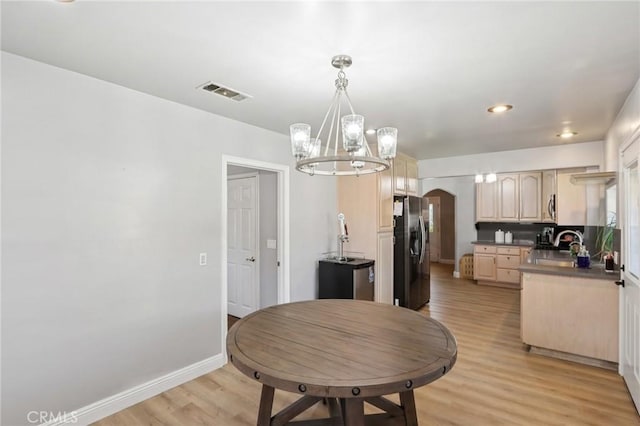 1776 San Bernardino Ave, Pomona, CA 91767 - kitchen with stainless steel refrigerator with ice dispenser, arched walkways, light brown cabinetry, a chandelier, and light wood finished floors