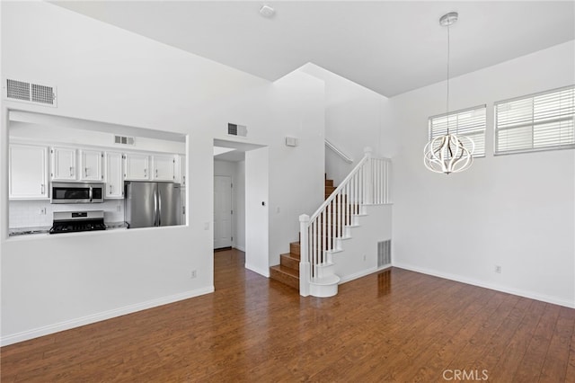 27884 Via De Costa, San Juan Capistrano, CA 92675 - unfurnished living room with stairs, a chandelier, and dark wood-style floors