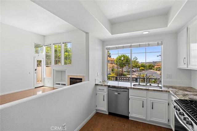27884 Via De Costa, San Juan Capistrano, CA 92675 - kitchen with stainless steel appliances, light stone countertops, dark wood-style flooring, and white cabinetry