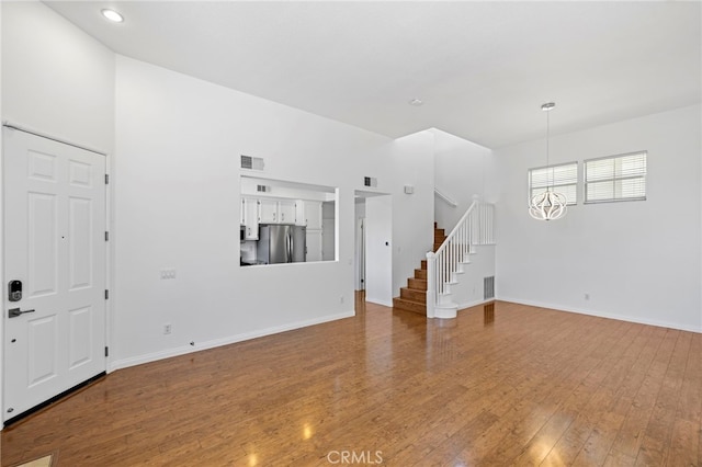 27884 Via De Costa, San Juan Capistrano, CA 92675 - unfurnished living room with stairs, wood finished floors, a chandelier, and recessed lighting