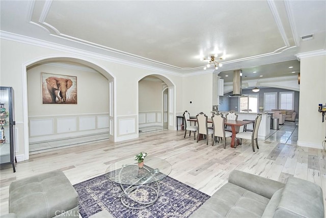 15446 Skyridge Dr, Riverside, CA 92503 - living room with arched walkways, crown molding, a decorative wall, wood finished floors, and a wainscoted wall