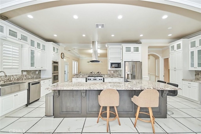 15446 Skyridge Dr, Riverside, CA 92503 - kitchen featuring stainless steel appliances, arched walkways, ornamental molding, a breakfast bar area, and backsplash