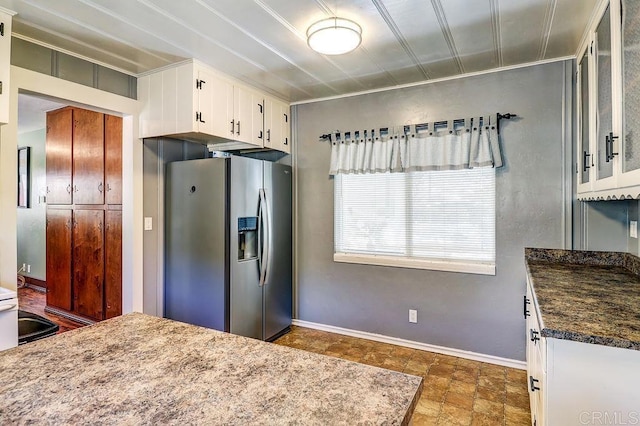 1242 Marshall Rd, Alpine, CA 91901 - kitchen featuring stainless steel fridge with ice dispenser, white cabinetry, stone finish floors, dark countertops, and glass insert cabinets