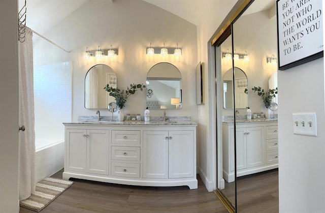 13425 Via Almeria, Tustin, CA 92782 - bathroom with lofted ceiling, double vanity, wood finished floors, and tiled tub