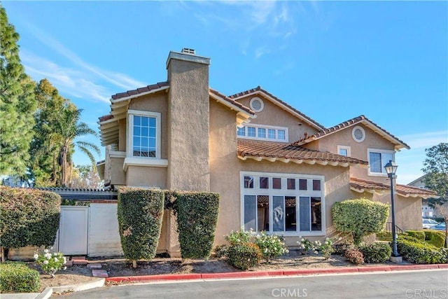 13425 Via Almeria, Tustin, CA 92782 - view of front of property featuring a chimney, stucco siding, and a tiled roof