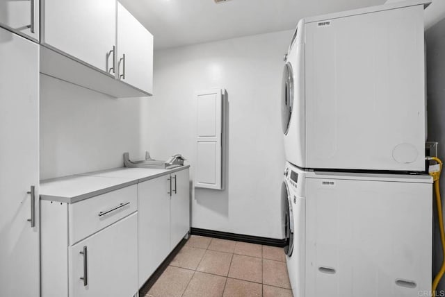 7439 Carrie Ridge Way, San Diego, CA 92139 - laundry area with cabinet space, stacked washer / dryer, and light tile patterned flooring