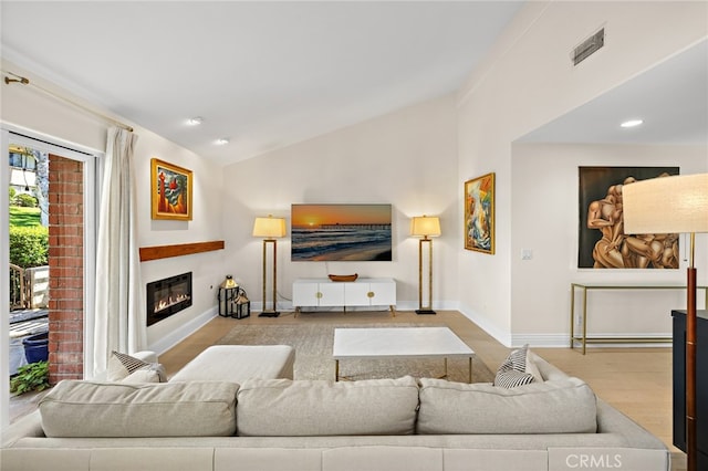 2719 Vista Umbrosa, Newport Beach, CA 92660 - living area with lofted ceiling, wood finished floors, a glass covered fireplace, and recessed lighting