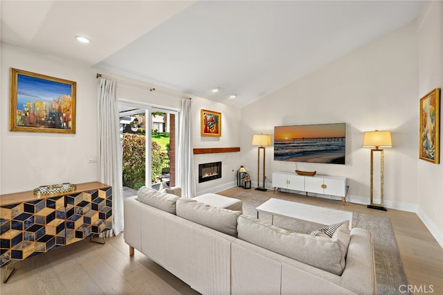 2719 Vista Umbrosa, Newport Beach, CA 92660 - living room with wood finished floors, vaulted ceiling, a glass covered fireplace, and recessed lighting