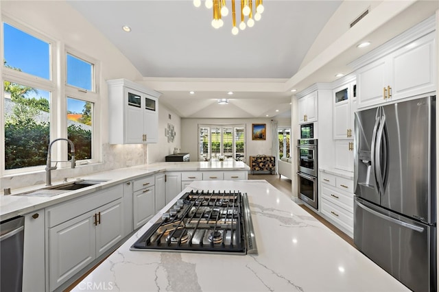 2719 Vista Umbrosa, Newport Beach, CA 92660 - kitchen featuring appliances with stainless steel finishes, vaulted ceiling, glass insert cabinets, white cabinetry, and recessed lighting
