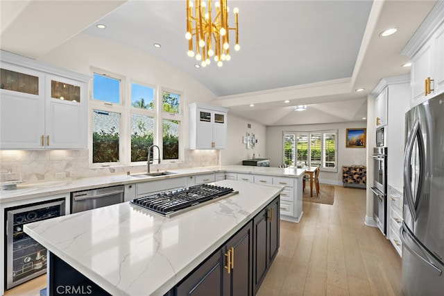 2719 Vista Umbrosa, Newport Beach, CA 92660 - kitchen with beverage cooler, appliances with stainless steel finishes, a peninsula, lofted ceiling, and white cabinetry
