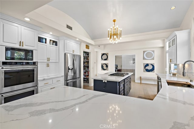 2719 Vista Umbrosa, Newport Beach, CA 92660 - kitchen with stainless steel appliances, lofted ceiling, white cabinetry, a chandelier, and glass insert cabinets