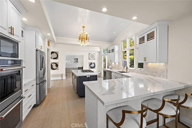 2719 Vista Umbrosa, Newport Beach, CA 92660 - kitchen featuring appliances with stainless steel finishes, a kitchen island, backsplash, a peninsula, and recessed lighting