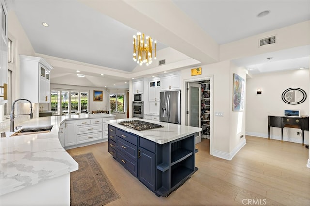 2719 Vista Umbrosa, Newport Beach, CA 92660 - kitchen featuring appliances with stainless steel finishes, blue cabinetry, white cabinets, a tray ceiling, and recessed lighting