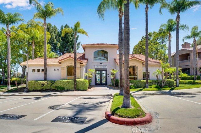 2500 San Gabriel Way Unit 306, Corona, CA 92882 - mediterranean / spanish home with a tile roof, stucco siding, french doors, and uncovered parking