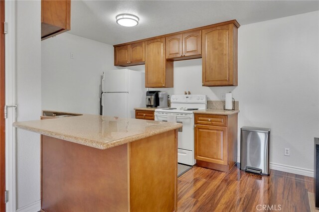 2500 San Gabriel Way Unit 306, Corona, CA 92882 - kitchen with white appliances, wood finished floors, light stone countertops, and brown cabinetry