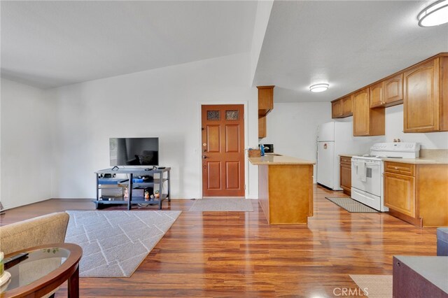 2500 San Gabriel Way Unit 306, Corona, CA 92882 - kitchen with white appliances, open floor plan, light wood finished floors, light countertops, and a peninsula