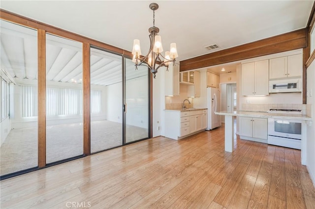 2605 Robinson St, Redondo Beach, CA 90278 - kitchen with white appliances, light countertops, a chandelier, light wood-type flooring, and white cabinets