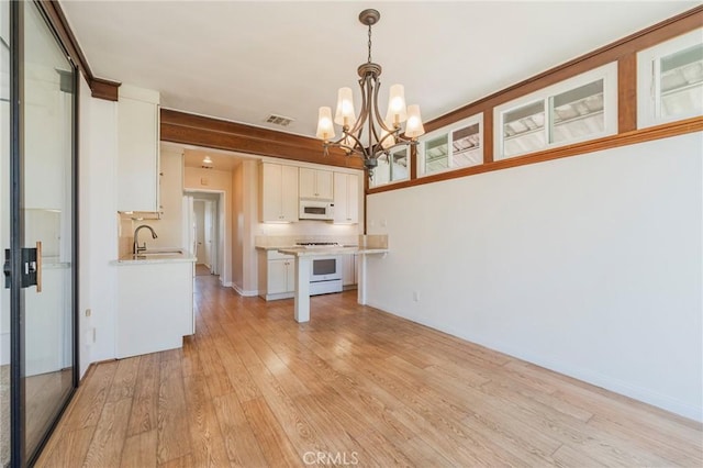 2605 Robinson St, Redondo Beach, CA 90278 - kitchen with white appliances, a chandelier, light wood-type flooring, and white cabinets