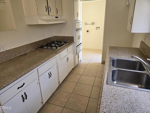 45409 Rodin Ave, Lancaster, CA 93535 - kitchen with stainless steel gas cooktop, under cabinet range hood, white cabinetry, a warming drawer, and light tile patterned floors