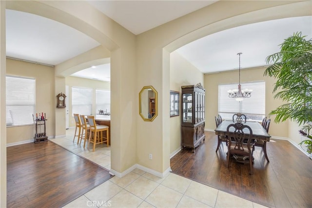 60284 Honeysuckle St, La Quinta, CA 92253 - dining area featuring a chandelier, light wood-type flooring, and arched walkways