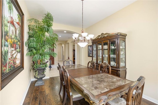 60284 Honeysuckle St, La Quinta, CA 92253 - dining space with arched walkways, a chandelier, and wood finished floors