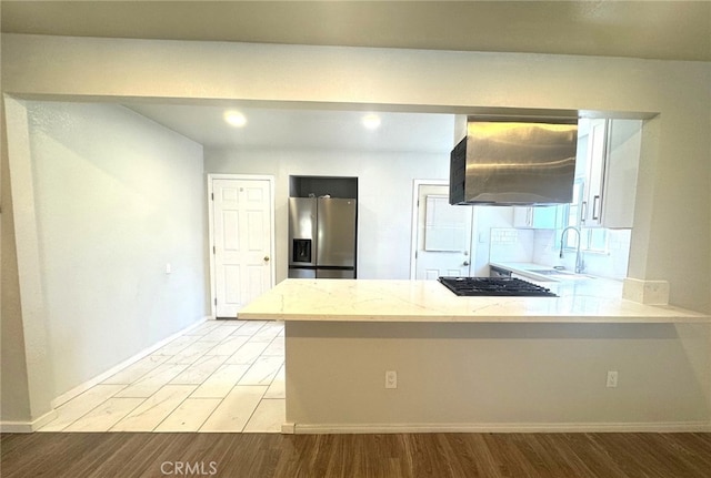 7892 8th St, Buena Park, CA 90621 - kitchen featuring stainless steel fridge, black gas cooktop, ventilation hood, a peninsula, and light wood finished floors