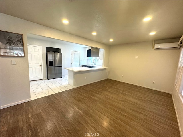 7892 8th St, Buena Park, CA 90621 - unfurnished living room featuring an AC wall unit, light wood finished floors, and recessed lighting