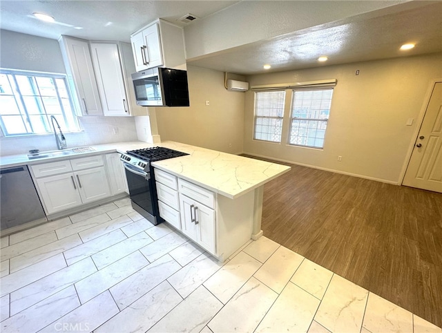 7892 8th St, Buena Park, CA 90621 - kitchen featuring stainless steel appliances, a wall mounted air conditioner, white cabinets, a peninsula, and tasteful backsplash