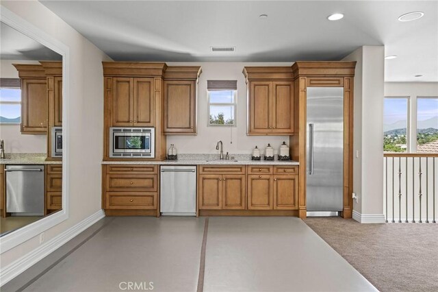 3 Stockmen Rd, Ladera Ranch, CA 92694 - kitchen with built in appliances, brown cabinetry, light stone countertops, and recessed lighting