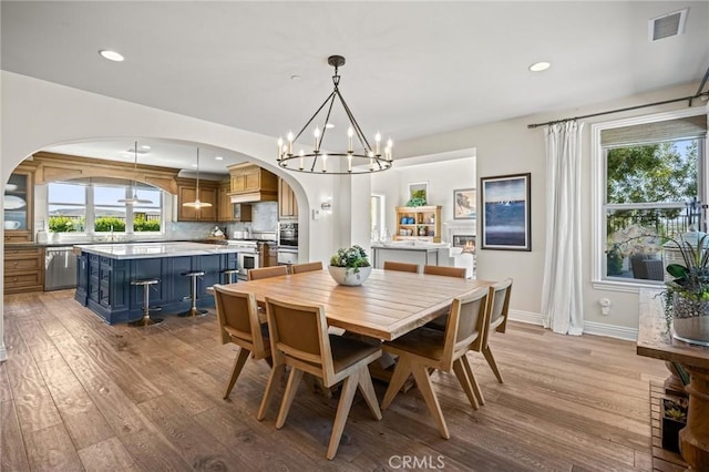 3 Stockmen Rd, Ladera Ranch, CA 92694 - dining room with arched walkways, light wood-style floors, a chandelier, and recessed lighting