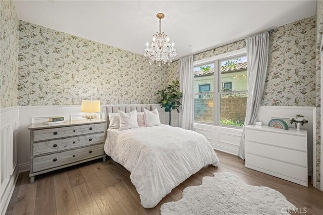 3 Stockmen Rd, Ladera Ranch, CA 92694 - bedroom featuring wallpapered walls, a wainscoted wall, a chandelier, and wood finished floors