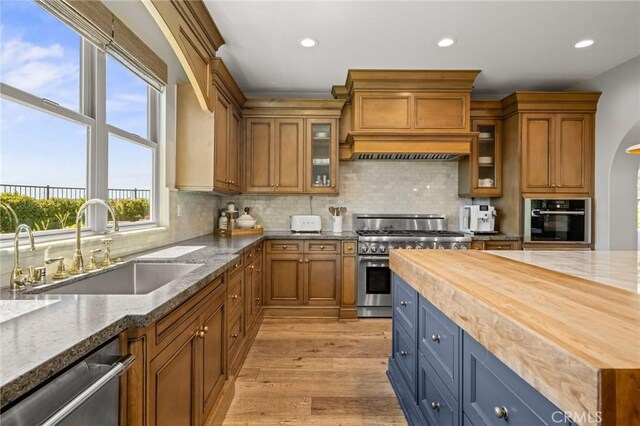 3 Stockmen Rd, Ladera Ranch, CA 92694 - kitchen featuring appliances with stainless steel finishes, brown cabinetry, recessed lighting, light stone counters, and light wood finished floors